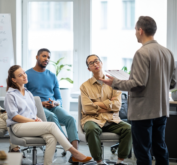 Instructor y equipo en capacitación presencial en sala de juntas