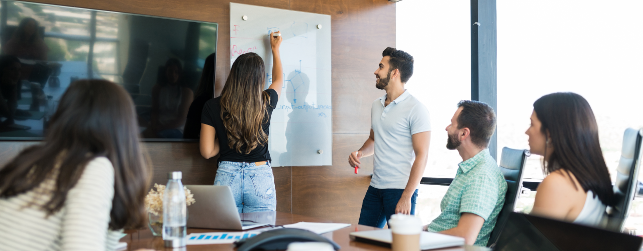 Equipo de trabajo tomando capacitación presencial con apoyo de presentaciones