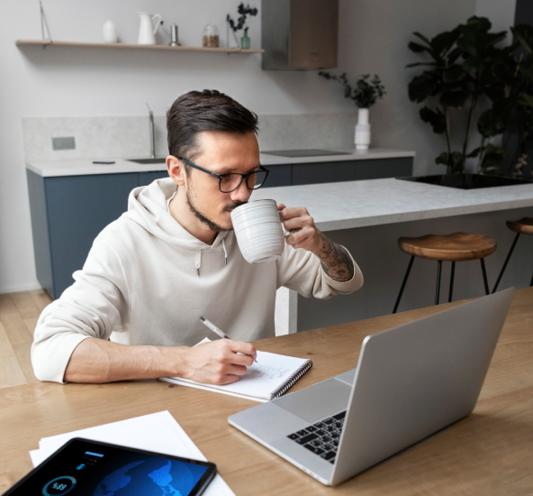 Persona en su escritorio tomando café y presentando examen Persona en su escritorio tomando café y presentando examen